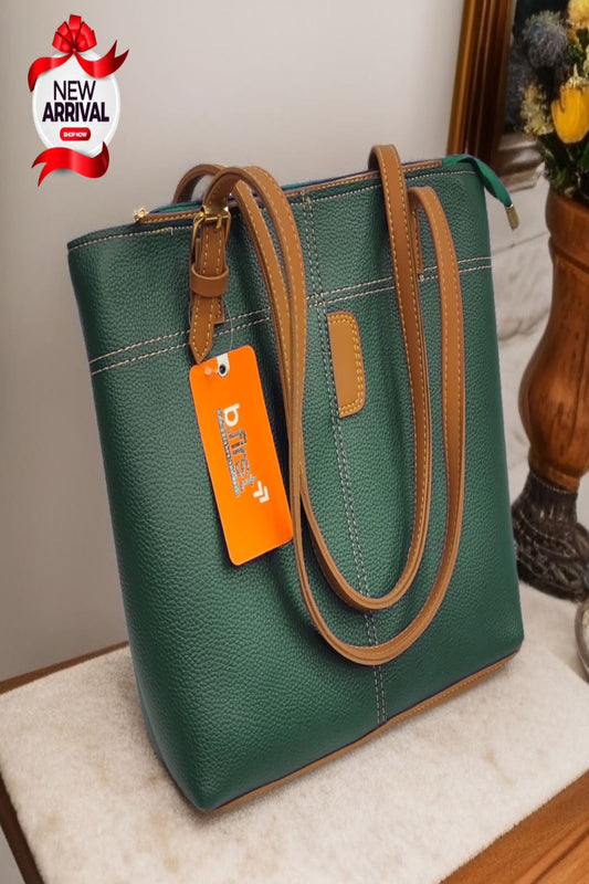 Green handbag with brown handles and an orange tag on a light surface.